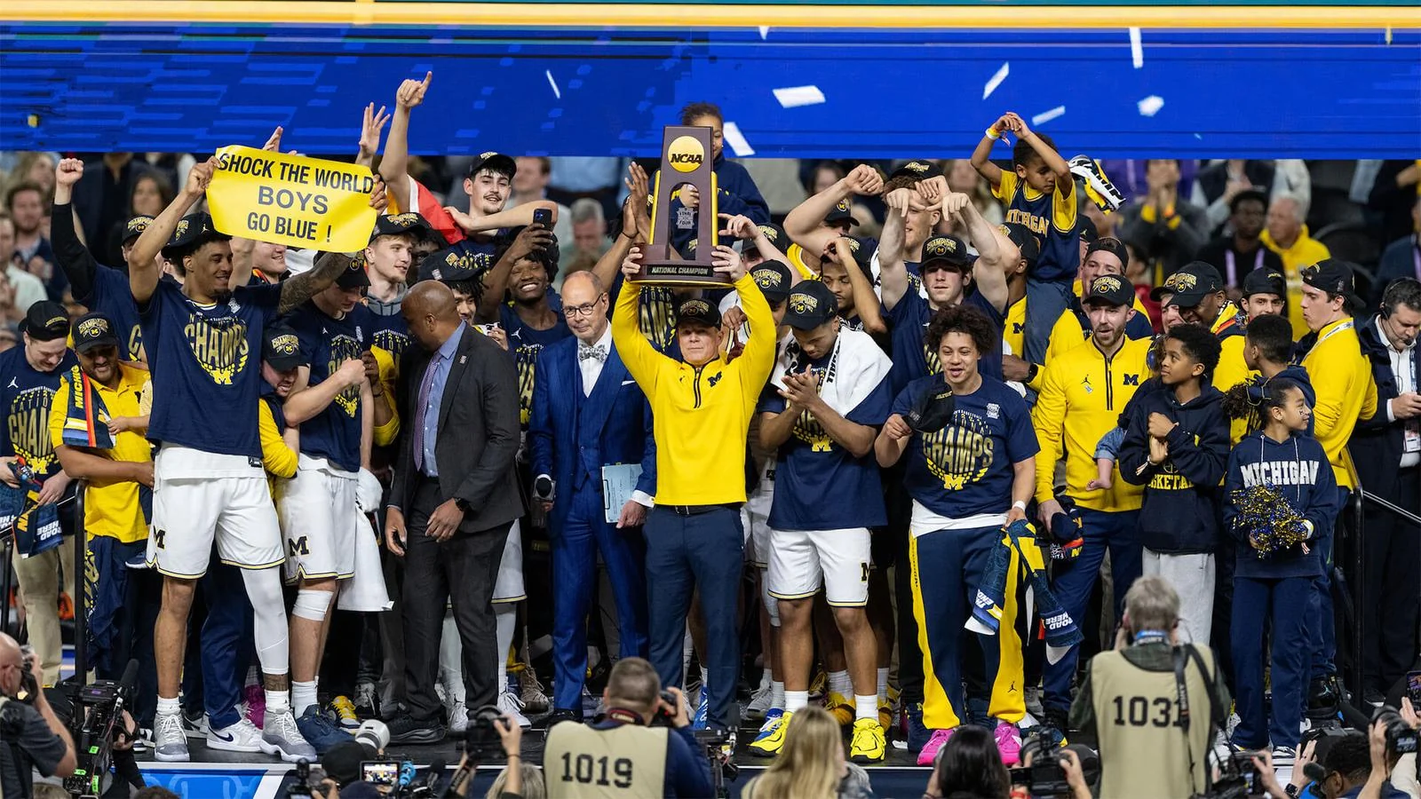 Michigan players and staff celebrating with the NCAA championship trophy