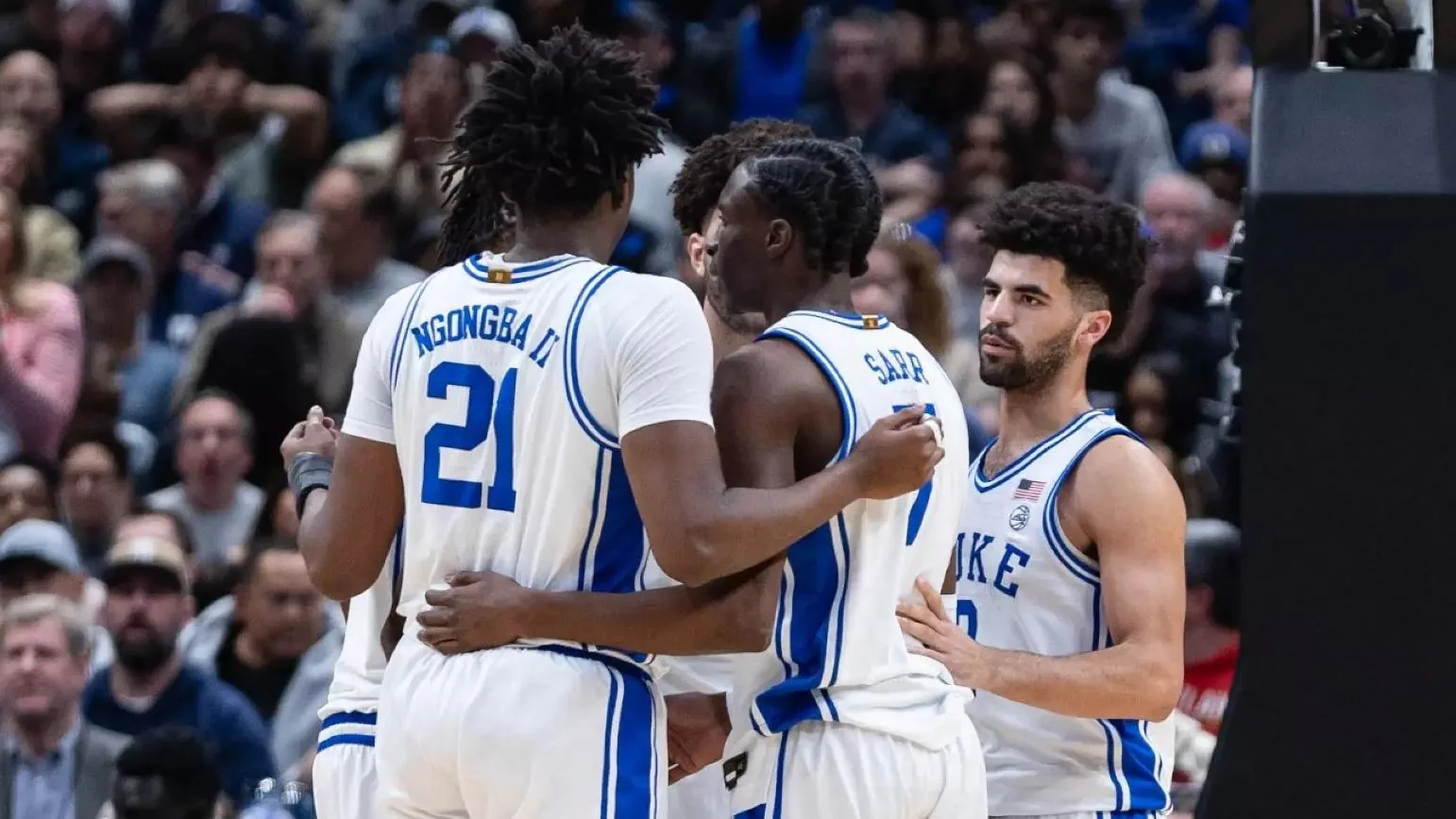 Duke men's basketball players gather in an on-court huddle