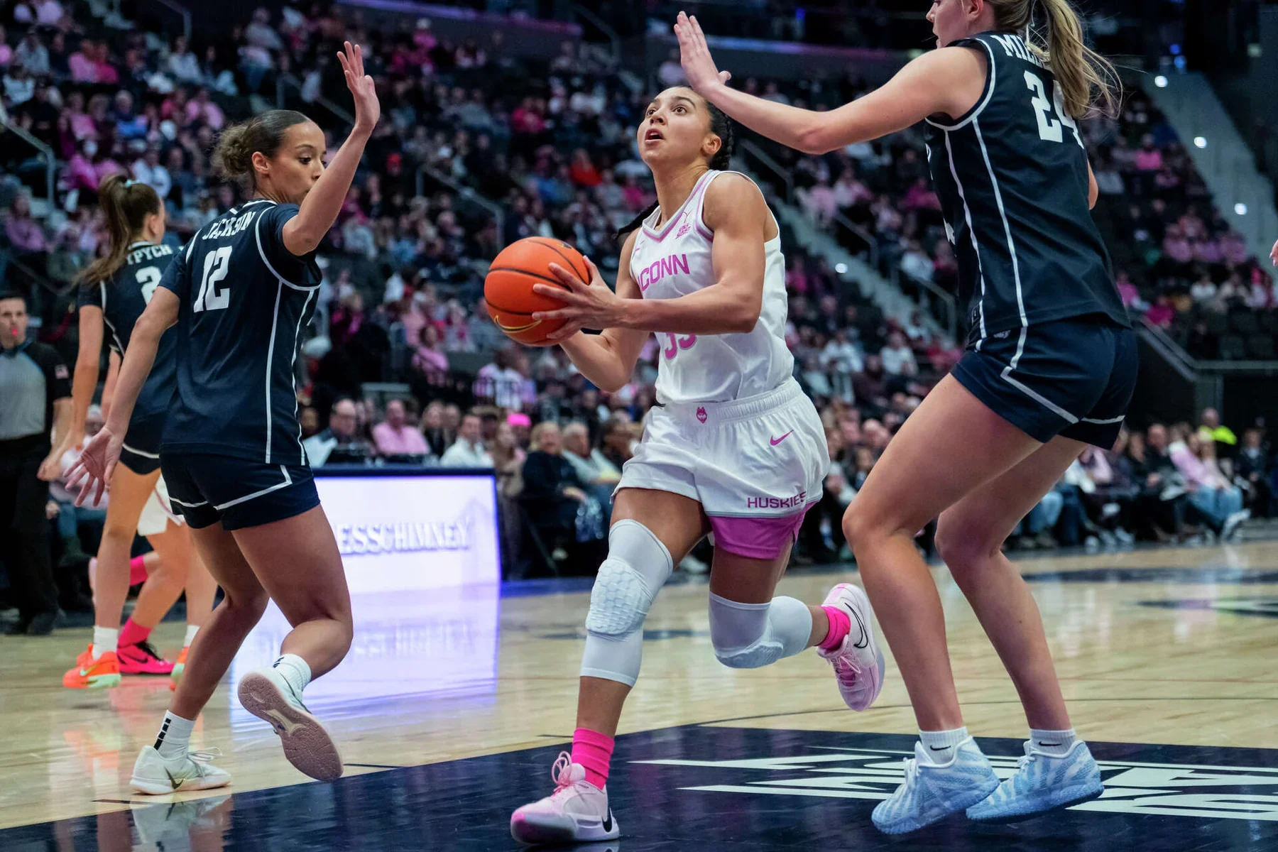 UConn ballhandler driving between two Butler defenders